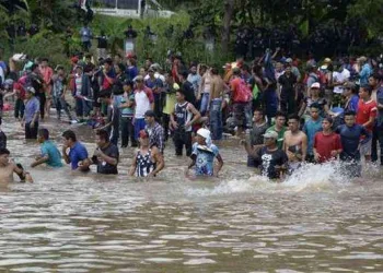 Centenas de hondurenhos entram no México cruzando rio fronteiriço