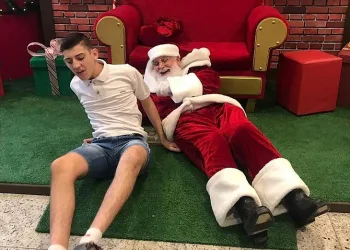 Papai Noel deita no chão para atender garoto autista e imagem viraliza nas redes