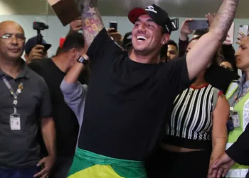 Medina desembarca com festa e bandeira do Brasil enrolada no corpo