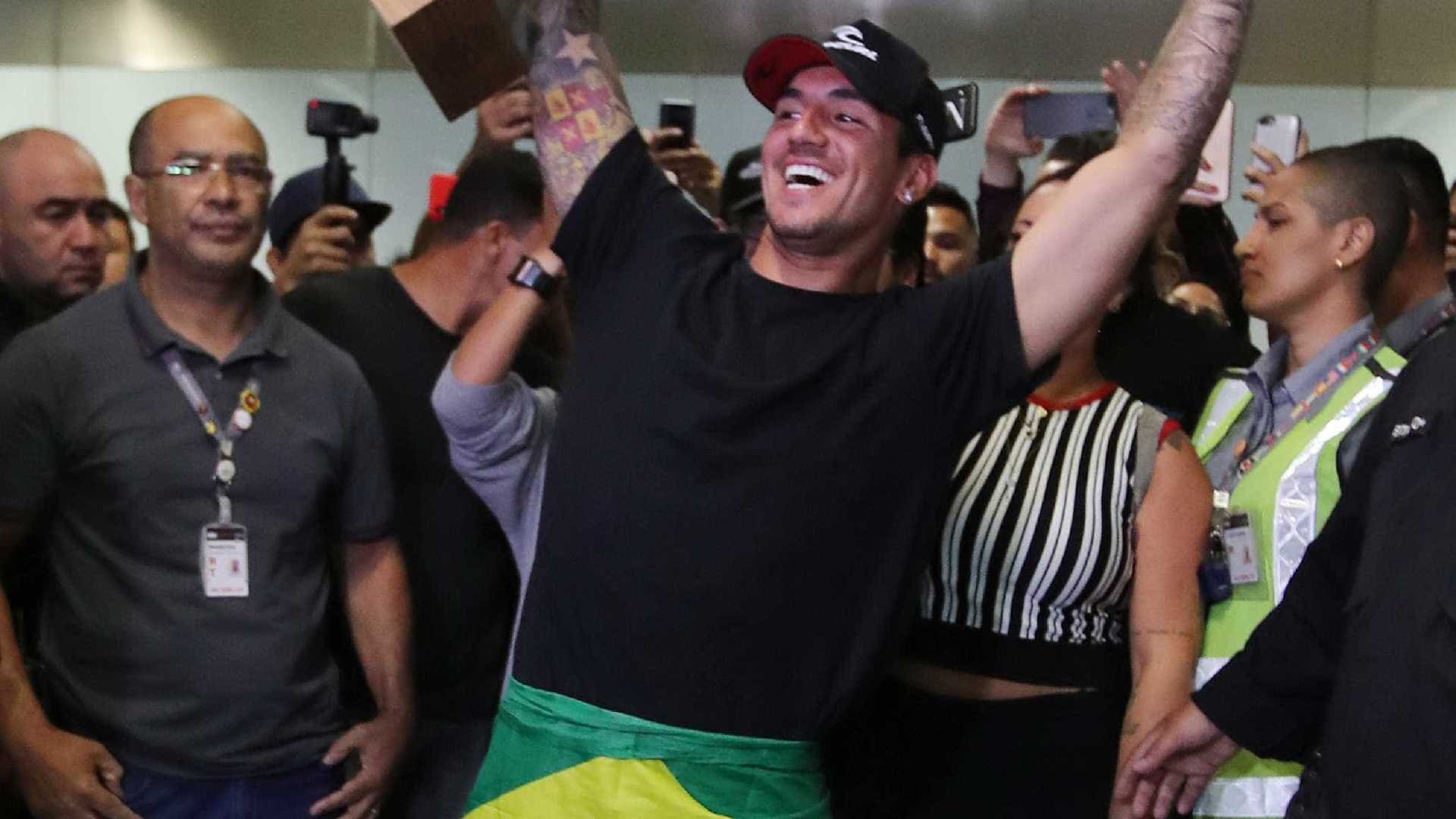 Medina desembarca com festa e bandeira do Brasil enrolada no corpo