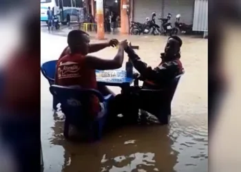 Moradores brindam em rua alagada no RJ