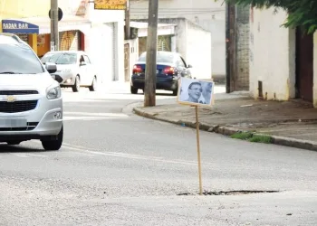 Moradores espalham placas com fotos do prefeito em buracos de rua