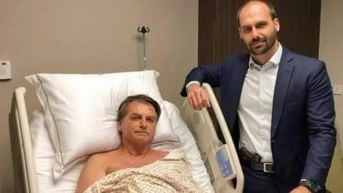 COM PISTOLA NA CINTURA, EDUARDO BOLSONARO POSA AO LADO DO PAI EM HOSPITAL