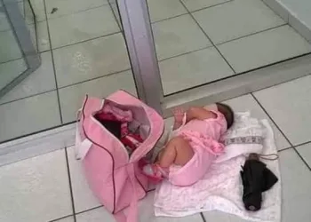 Barrada em porta giratória, mãe põe bebê no chão para entrar em banco.