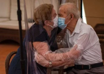 Amor em tempos de quarentena: casal usa cortina de plástico para se beijarem e emocionam